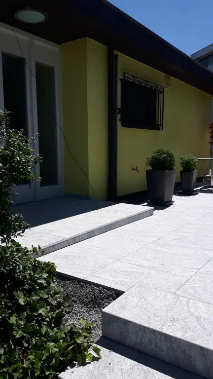 Terrasse vor einem gelben Haus