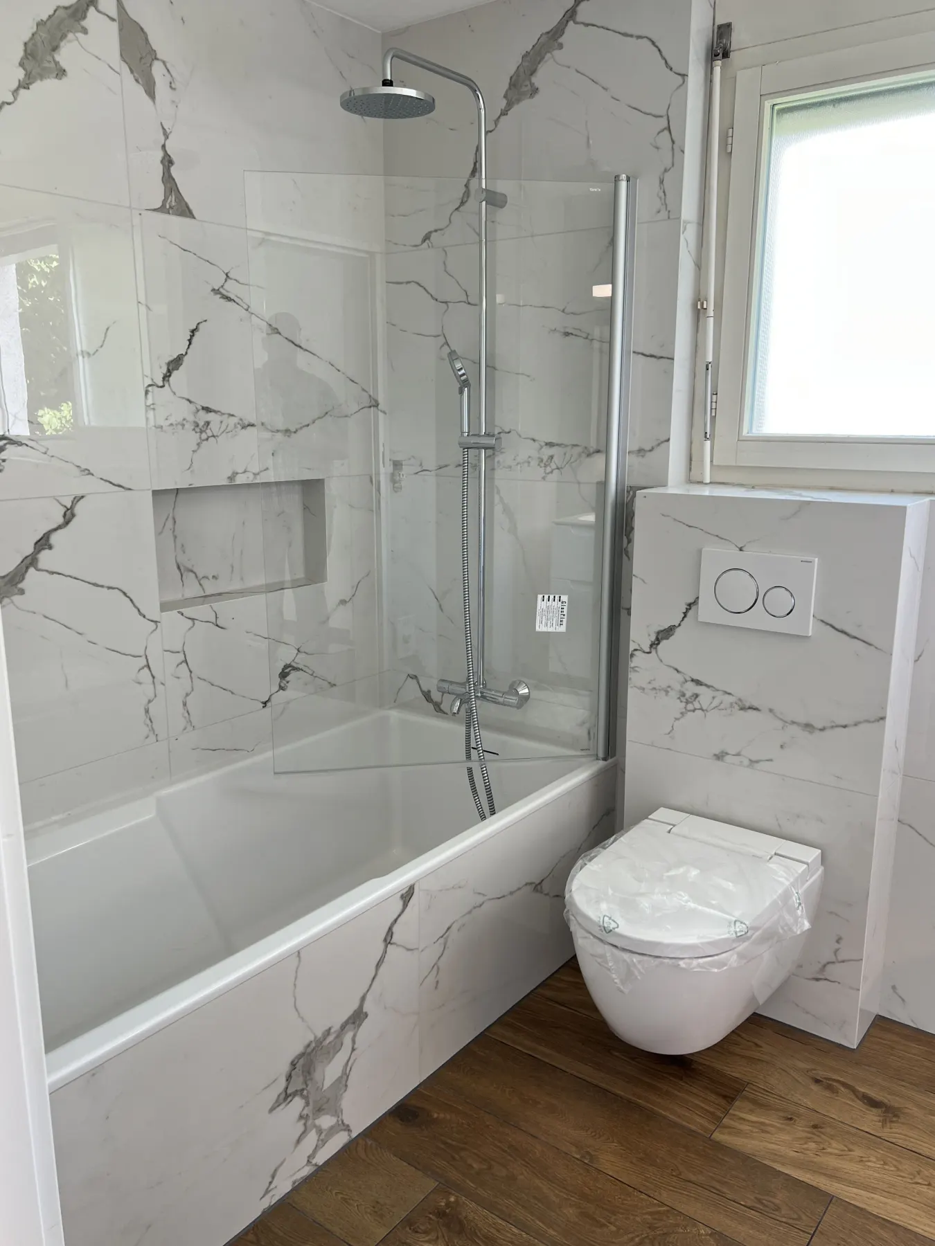 Badewanne und Wand in Marmoroptik mit Nische