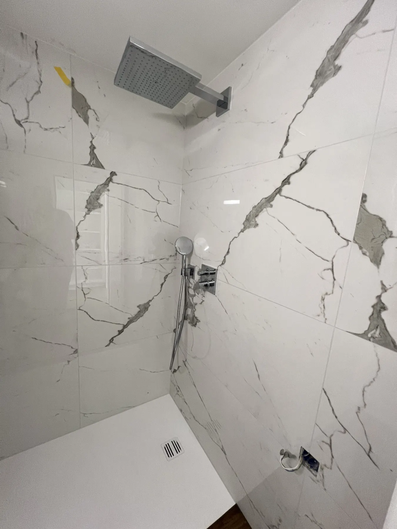 Dusche mit Marmoroptik-Platten und Regendusche