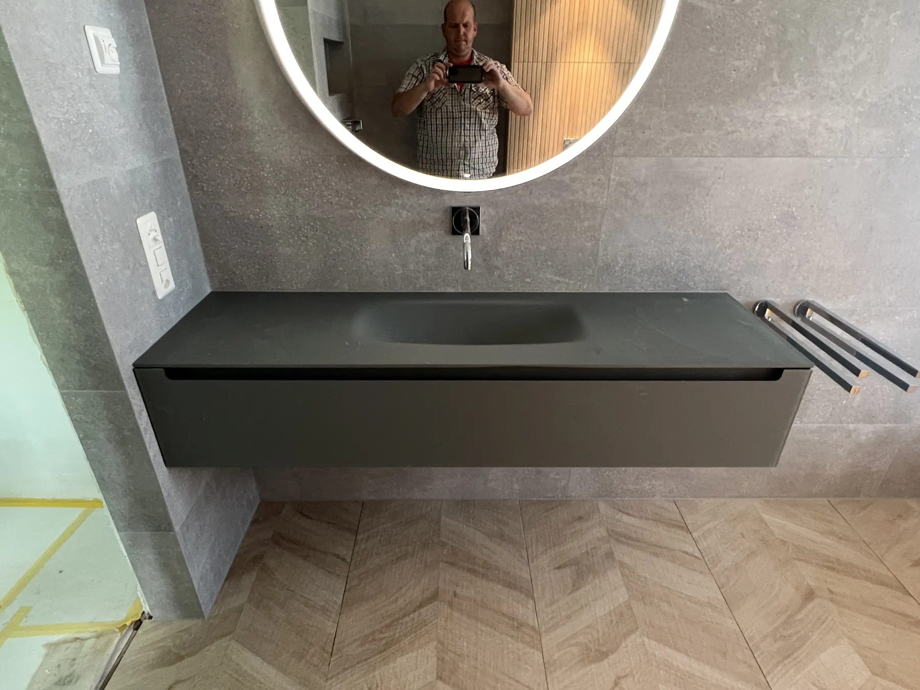 Badezimmer mit Boden in Holzoptik und Waschtisch