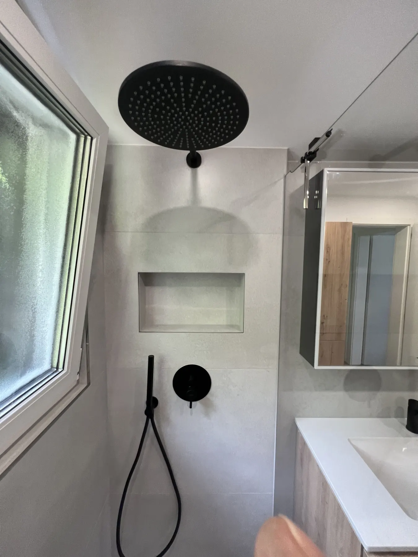 Dusche mit schwarzer Armatur und Nische