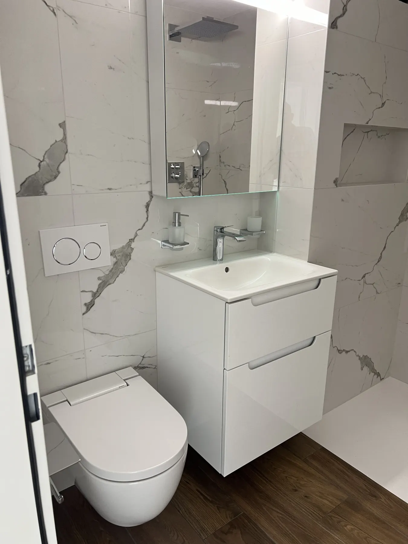Bad mit Wänden in Marmoroptik und Boden in Holzoptik