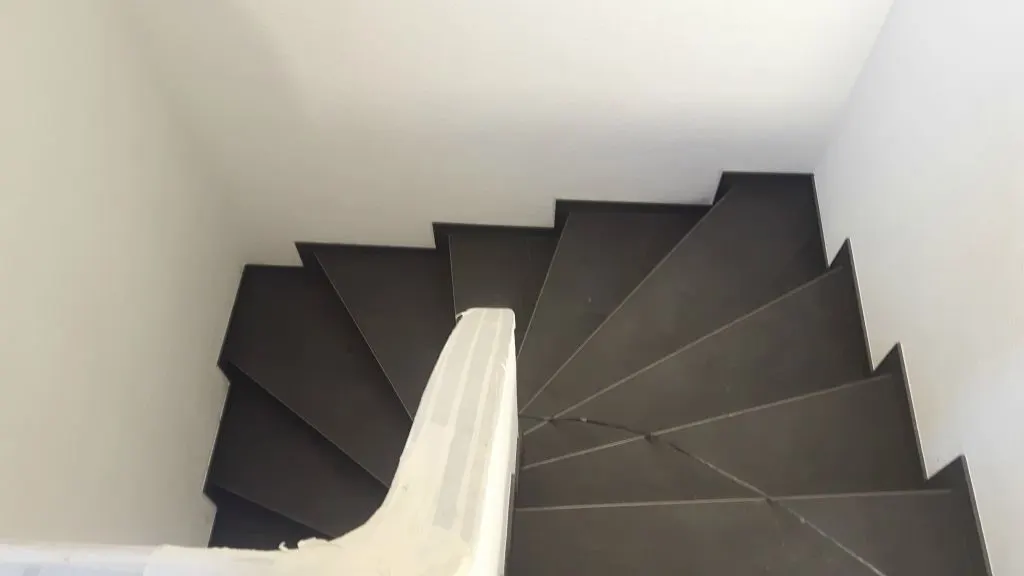 Gewendelte Treppe mit dunklen Stufen von oben