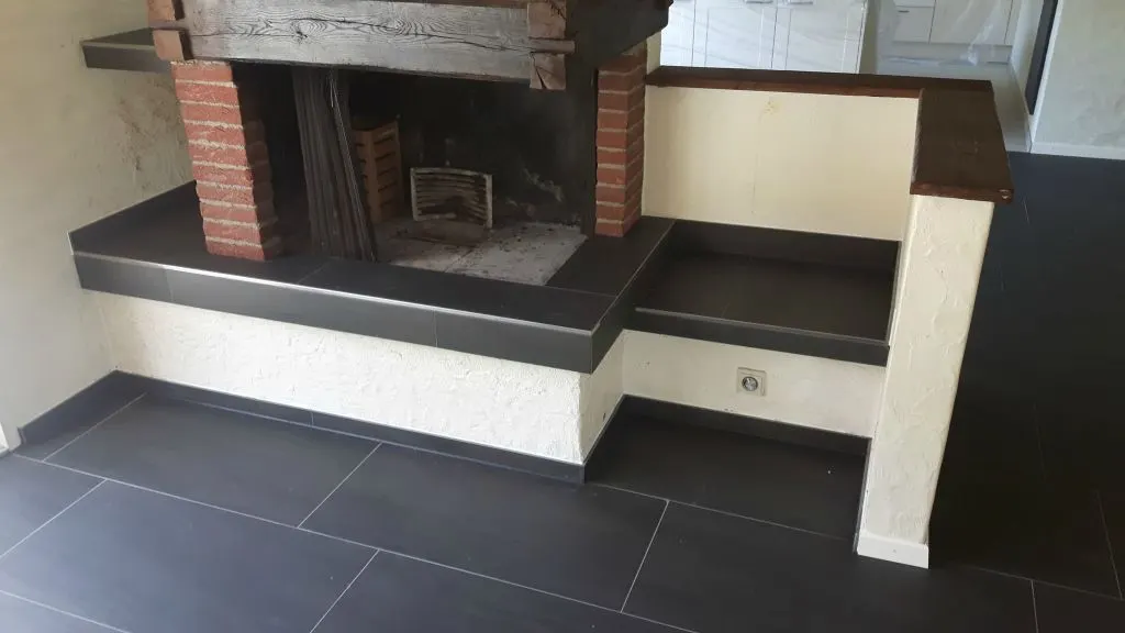 Dunkler Plattenboden vor dem Cheminée