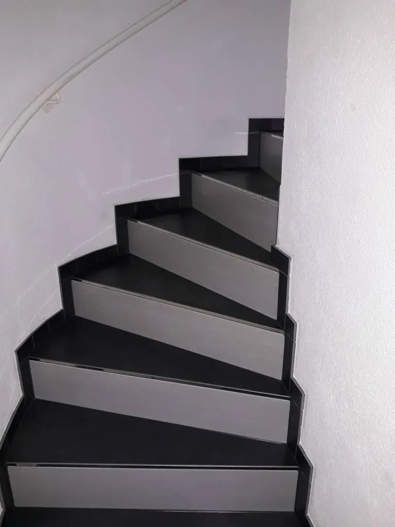 Gewendelte Treppe mit Platten in Grau