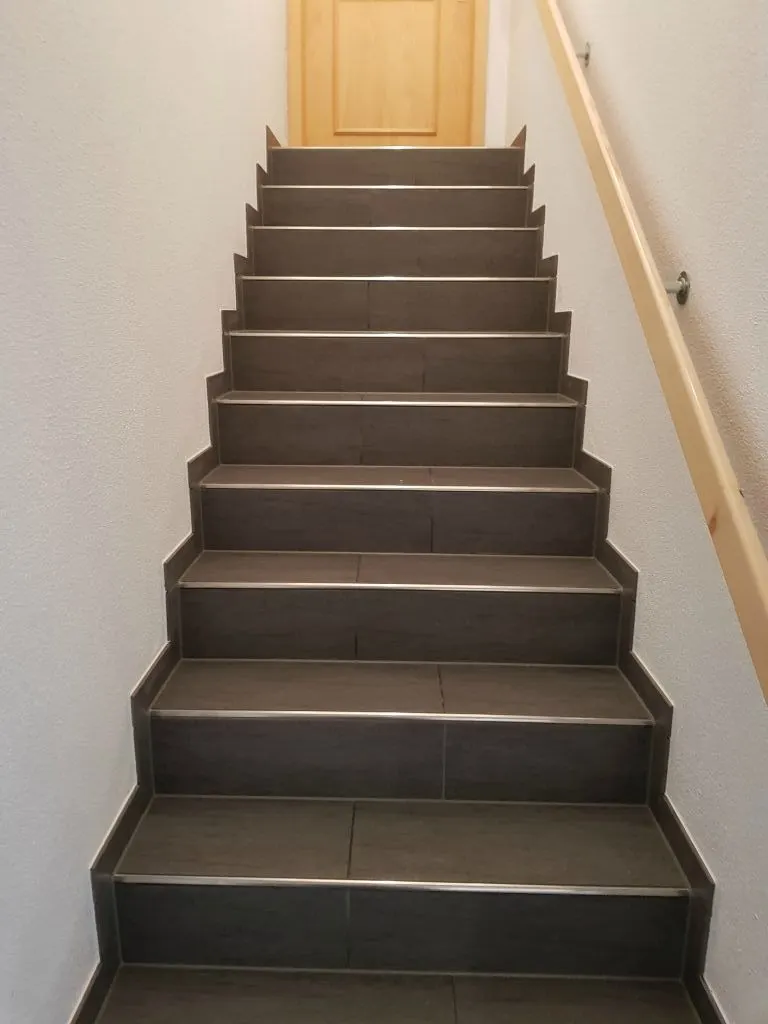 Gerade Treppe mit dunklen Stufen und Kantenprofilen