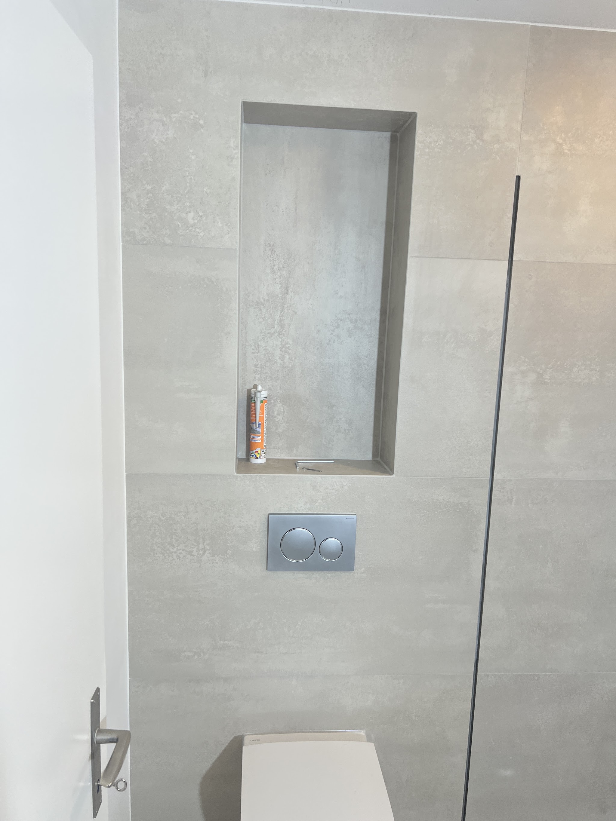 WC und Duschnische mit hellen Grossformatplatten